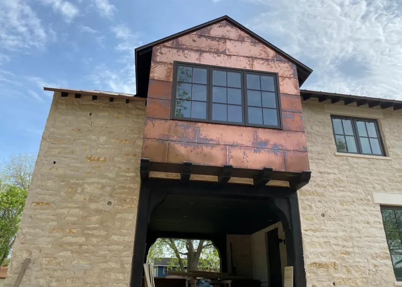 Copper metal panel facade on a stone building for Skylight Installation in Nazareth