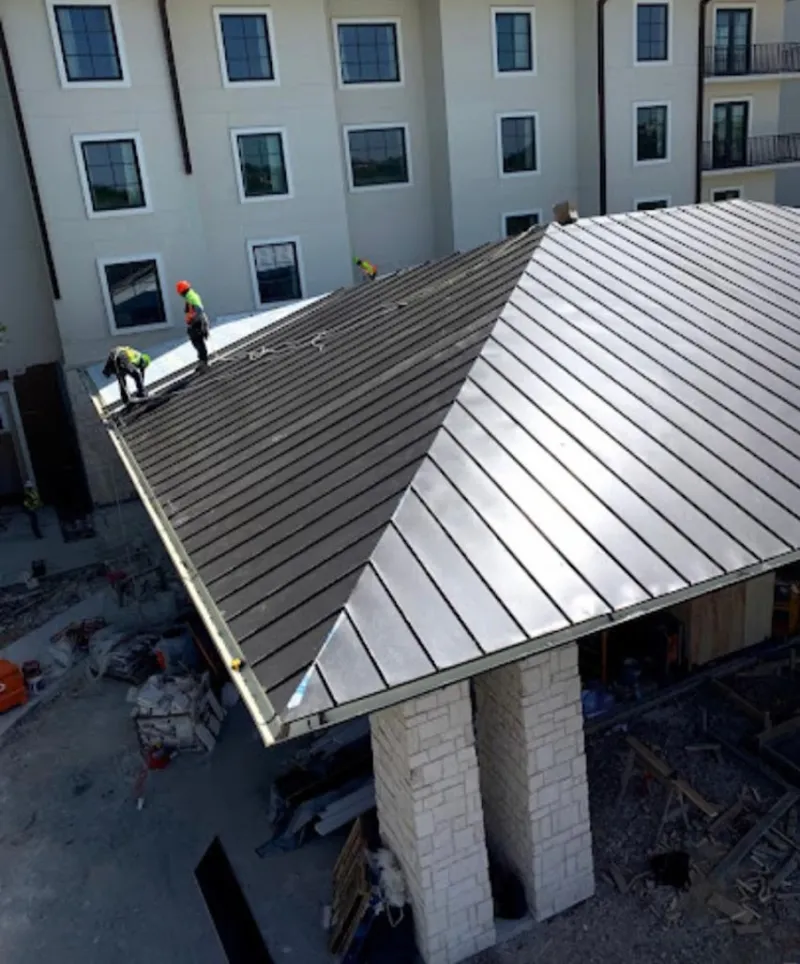 Crew installing standing seam metal roof panels on a commercial project in Nazareth